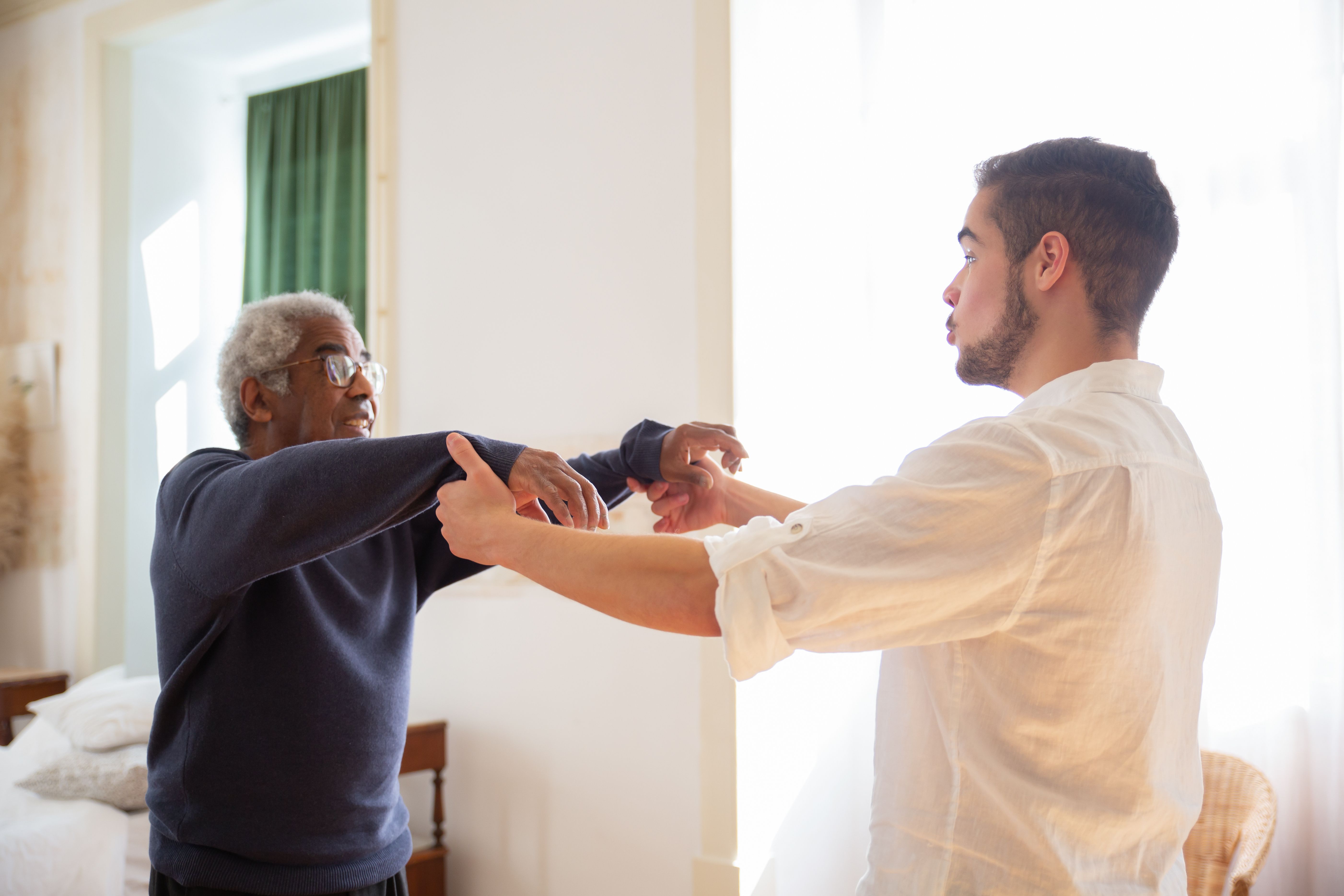 A caregiver offers an older adult companionship and support at home, showing how connection can be part of a paid service.
