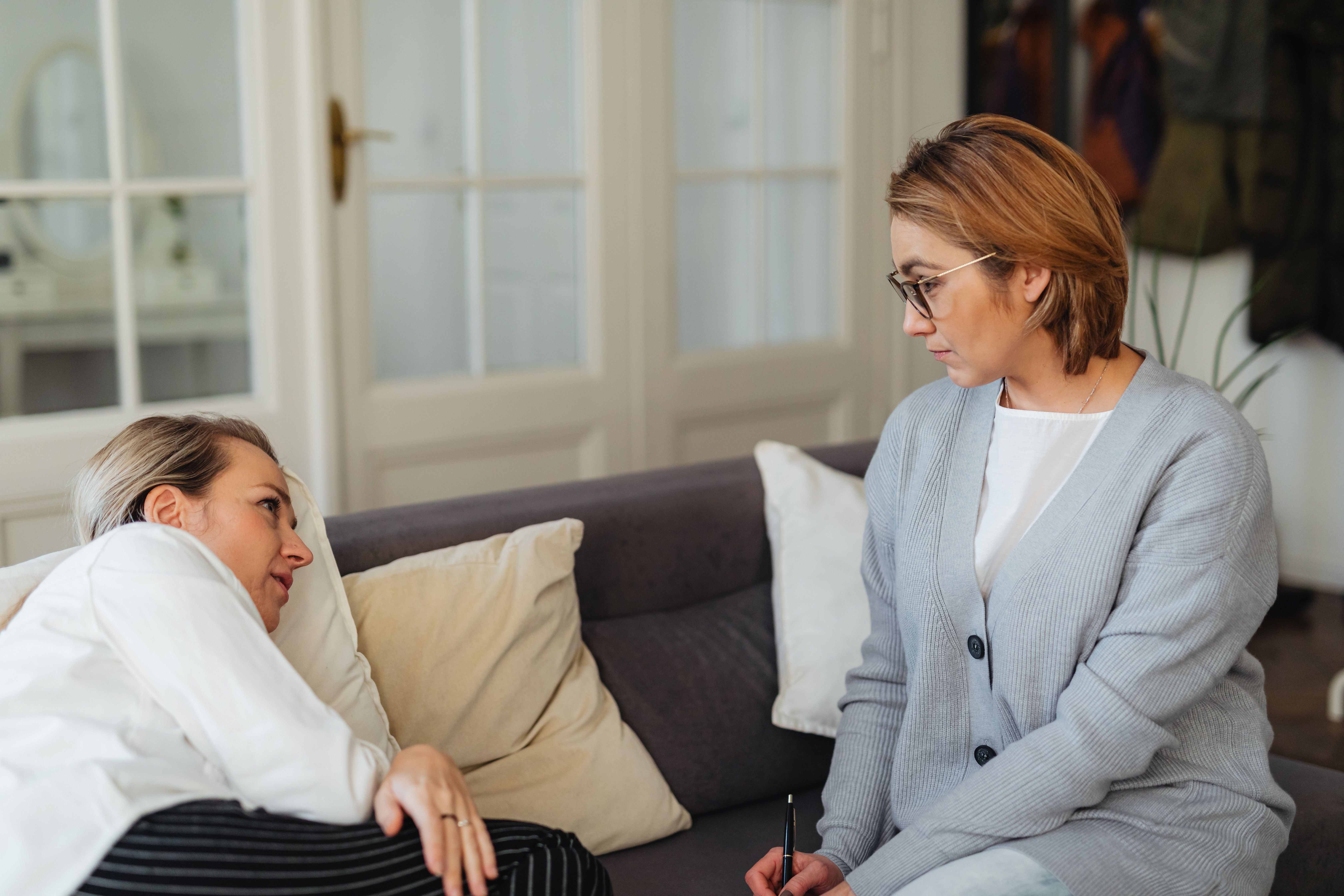 A counselor listens closely to a client during a one-to-one conversation, representing the growing market for attentive listening.